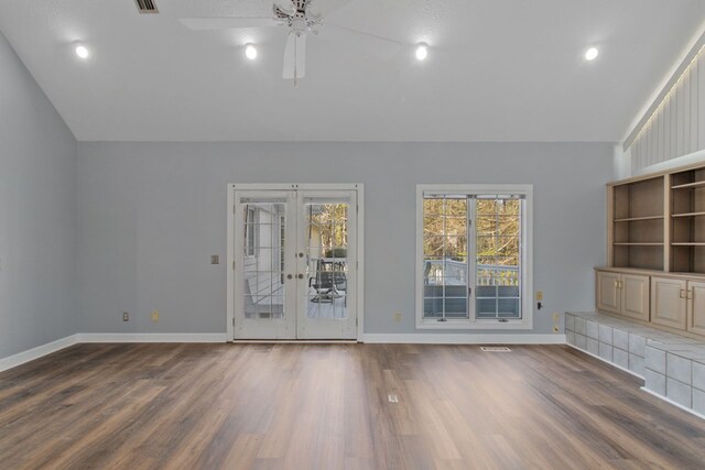 unfurnished living room with ceiling fan, lofted ceiling, and dark wood-type flooring