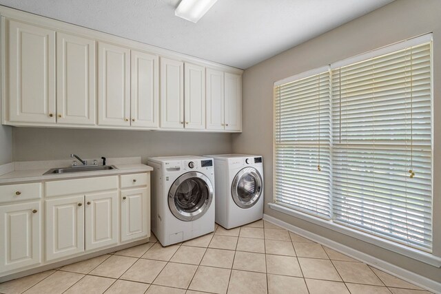 485 Boyd Branch Dr, Upatoi, GA 31829 - laundry area featuring cabinet space, washing machine and clothes dryer, light tile patterned floors, baseboards, and plenty of natural light