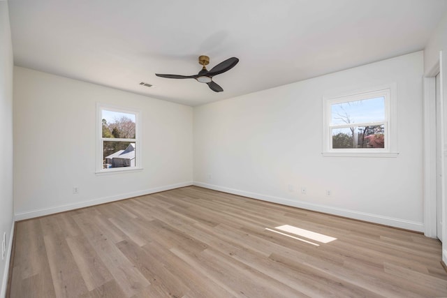 empty room with a ceiling fan, light wood-type flooring, visible vents, and baseboards