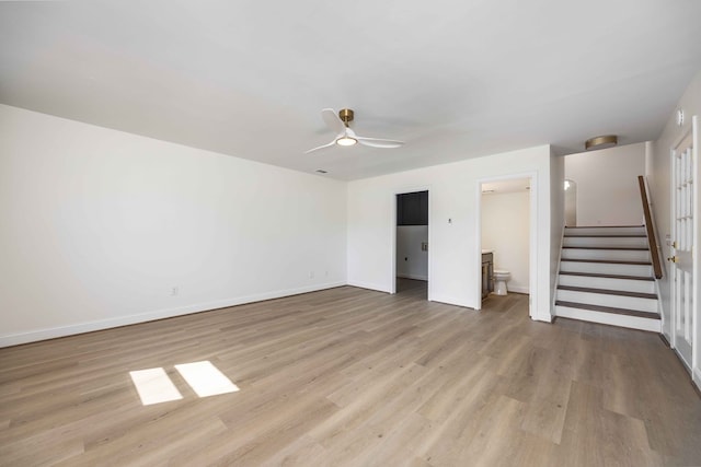 unfurnished bedroom featuring light wood-style floors, connected bathroom, baseboards, and a ceiling fan