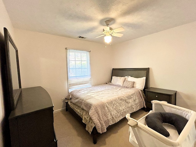 bedroom with ceiling fan, a textured ceiling, and dark colored carpet