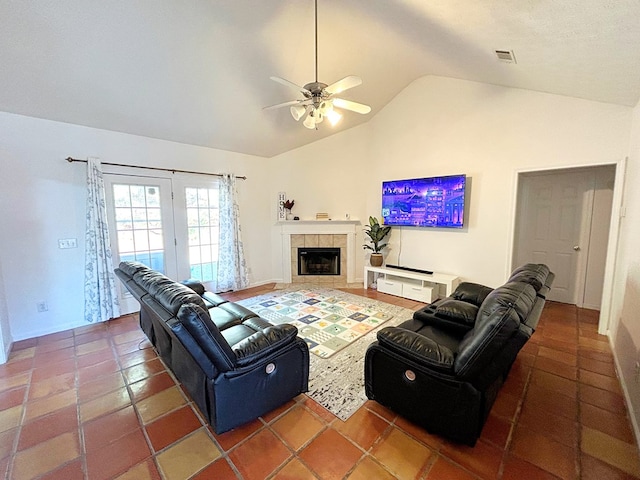 living room with tile patterned flooring, high vaulted ceiling, ceiling fan, and a tiled fireplace