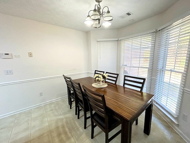 dining area featuring a textured ceiling and an inviting chandelier