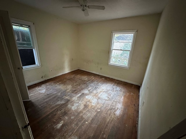 spare room featuring dark wood-type flooring and ceiling fan