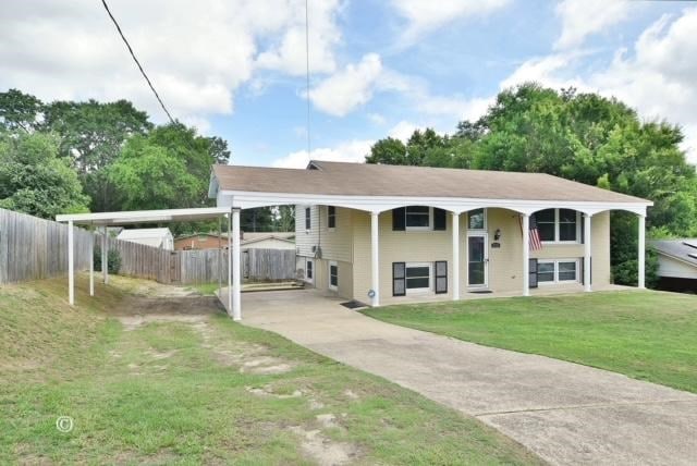 view of front facade with a front yard and a carport