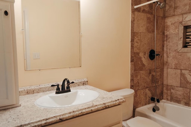 full bathroom featuring vanity, tiled shower / bath, and toilet