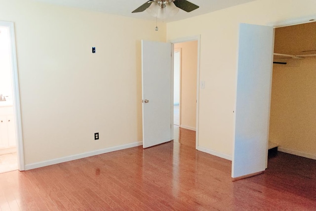 unfurnished bedroom featuring hardwood / wood-style floors, ceiling fan, and a closet