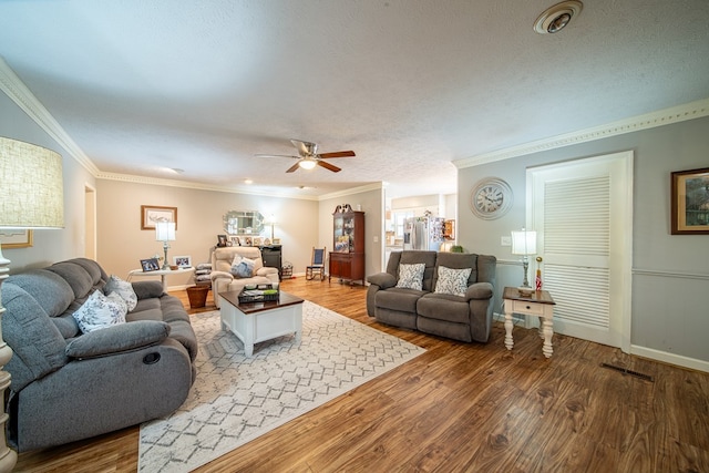 living room featuring hardwood / wood-style flooring, crown molding, ceiling fan, and a textured ceiling