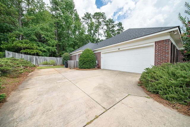 4548 Carnoustie Ln, Columbus, GA 31909 - view of side of property featuring brick siding, driveway, roof with shingles, and a garage