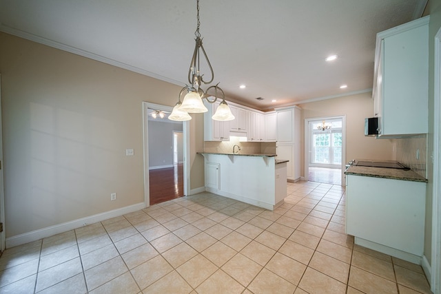 4548 Carnoustie Ln, Columbus, GA 31909 - kitchen with a chandelier, a peninsula, ornamental molding, backsplash, and light tile patterned flooring