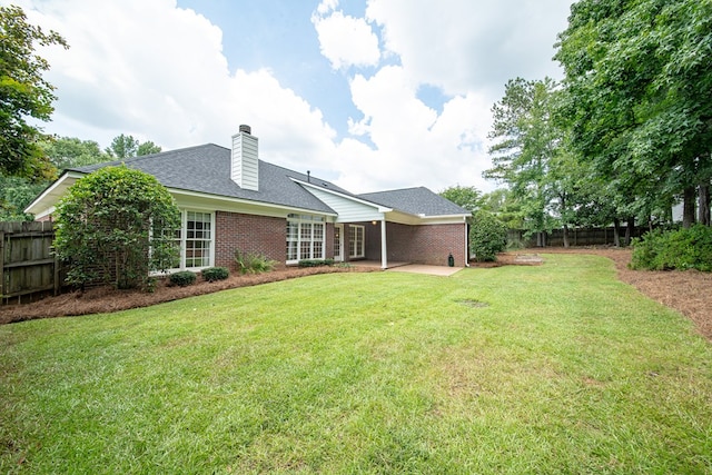 4548 Carnoustie Ln, Columbus, GA 31909 - rear view of house featuring brick siding, a patio, a chimney, and a shingled roof