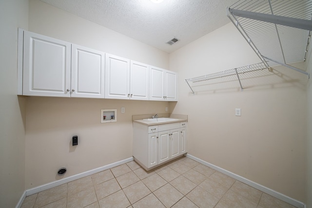 4548 Carnoustie Ln, Columbus, GA 31909 - laundry area with washer hookup, cabinet space, hookup for an electric dryer, light tile patterned flooring, and a textured ceiling