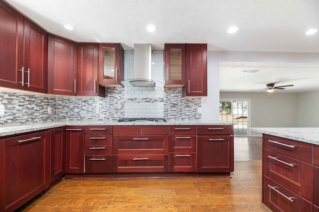 3409 Primrose Rd, Columbus, GA 31907 - kitchen featuring wall chimney range hood, reddish brown cabinets, wood finished floors, ceiling fan, and recessed lighting