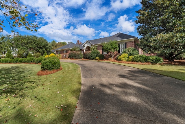 single story home featuring a front lawn