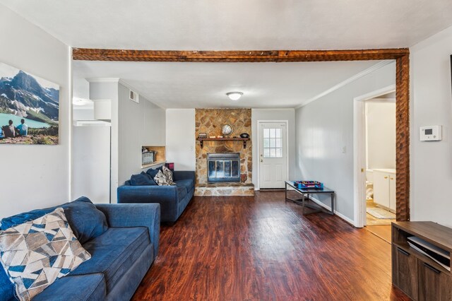 living room featuring dark hardwood / wood-style floors, crown molding, and a stone fireplace