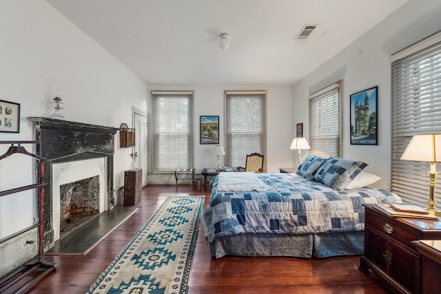 171 Jefferson Ave, Talbotton, GA 31827 - bedroom with visible vents, multiple windows, wood finished floors, and a fireplace