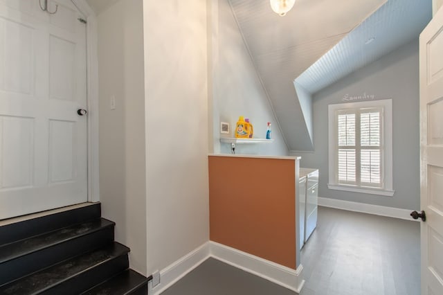 interior space with lofted ceiling, washer and clothes dryer, and wood-type flooring