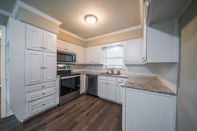 3 Primrose Ct, Columbus, GA 31907 - kitchen with stainless steel appliances, crown molding, dark wood-style floors, white cabinetry, and light stone countertops