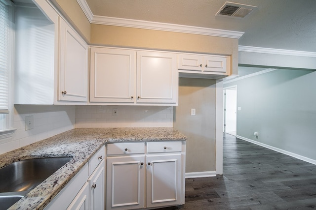 3 Primrose Ct, Columbus, GA 31907 - kitchen with crown molding, decorative backsplash, dark wood-type flooring, white cabinets, and light stone countertops