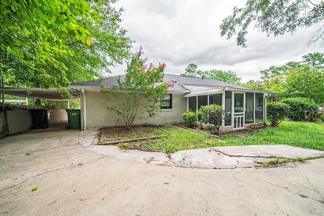 3 Primrose Ct, Columbus, GA 31907 - rear view of house with a sunroom, a carport, driveway, brick siding, and a shingled roof