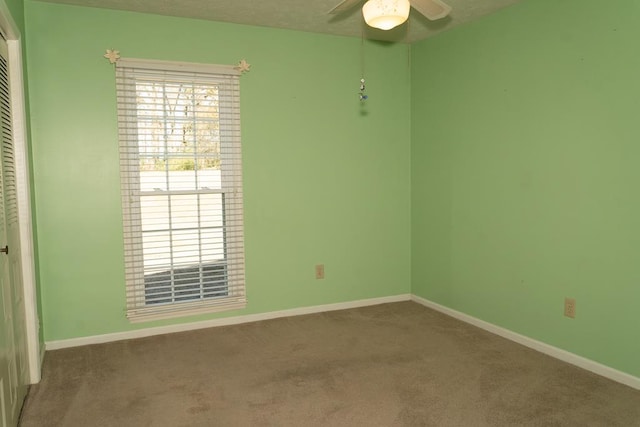 carpeted empty room featuring ceiling fan and a textured ceiling