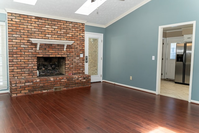 unfurnished living room featuring ornamental molding, a fireplace, hardwood / wood-style floors, and lofted ceiling with skylight