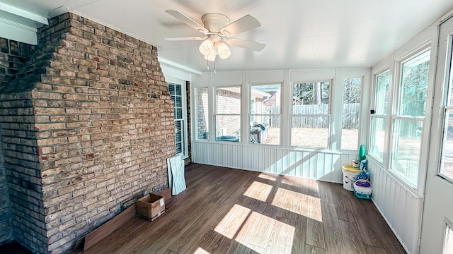 unfurnished sunroom featuring ceiling fan and a healthy amount of sunlight