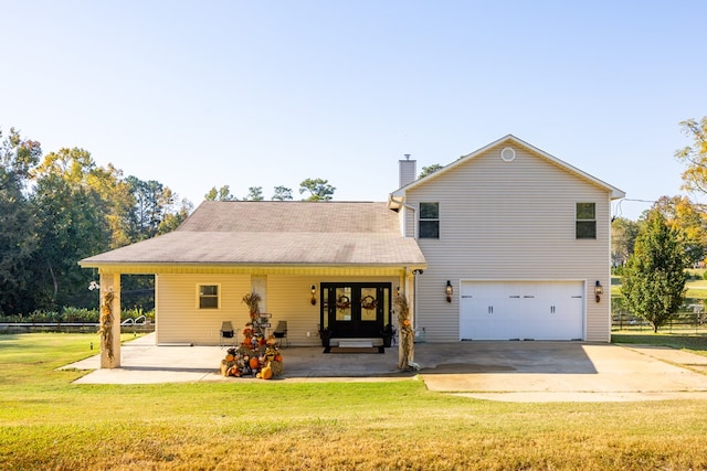 rear view of house with a yard and a garage