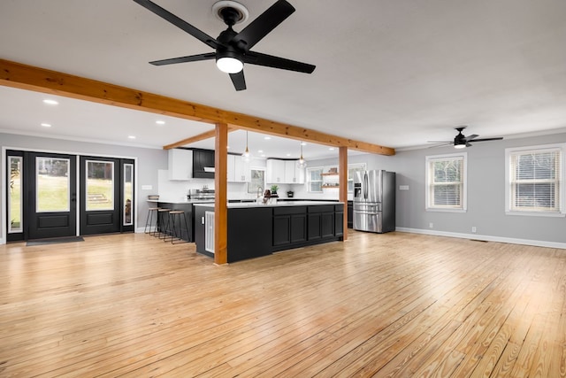 unfurnished living room with light hardwood / wood-style floors, ceiling fan, and ornamental molding