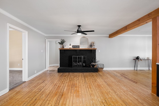 living room with ceiling fan, crown molding, beam ceiling, a fireplace, and hardwood / wood-style floors