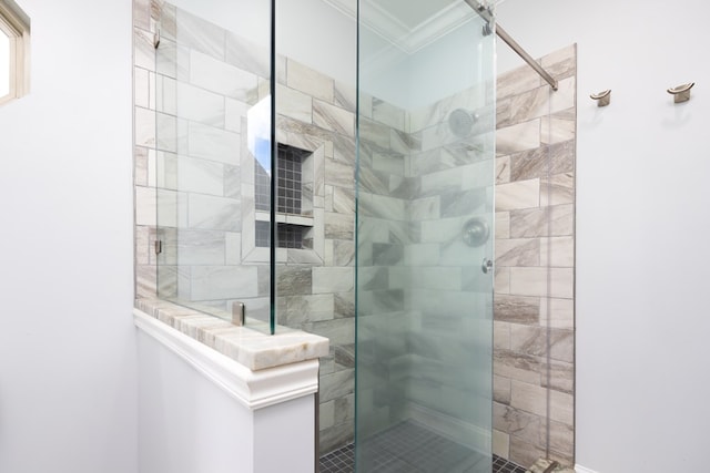 bathroom with crown molding and tiled shower