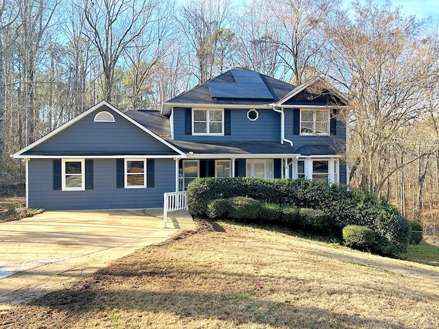 view of property with a front lawn and solar panels