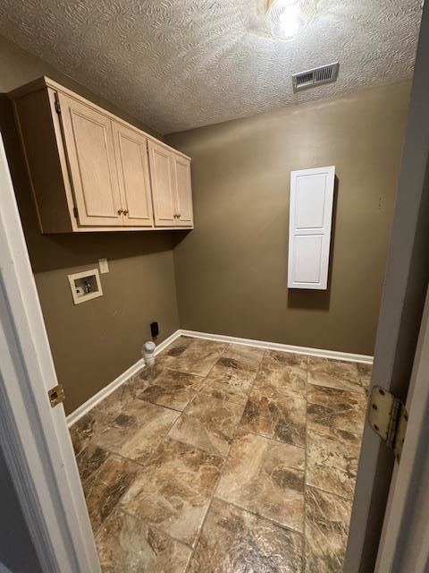 washroom with cabinets, a textured ceiling, and hookup for a washing machine