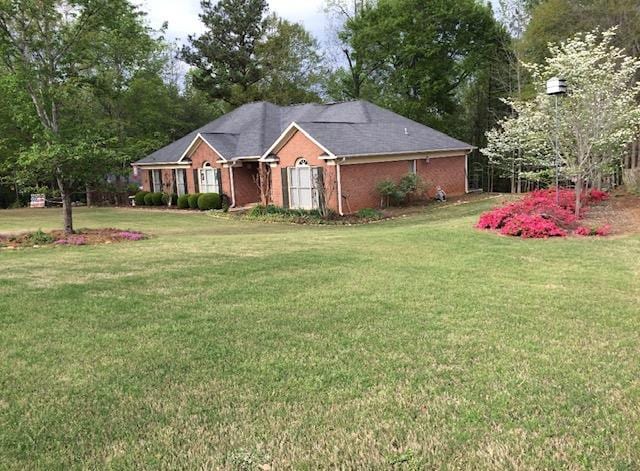 ranch-style home featuring a front lawn