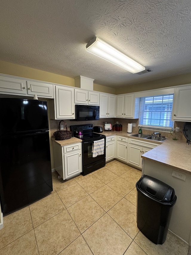 3802 Holland Ct, Phenix City, AL 36867 - kitchen featuring black appliances, white cabinets, light tile patterned floors, light countertops, and a textured ceiling