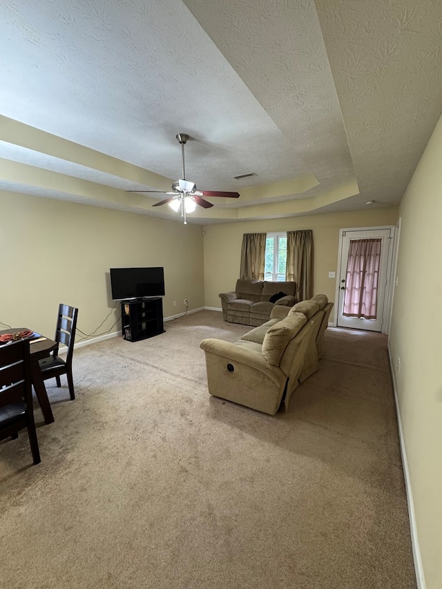 3802 Holland Ct, Phenix City, AL 36867 - living area with carpet floors, a textured ceiling, a ceiling fan, and a tray ceiling