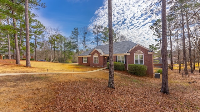 single story home with a front yard and central air condition unit