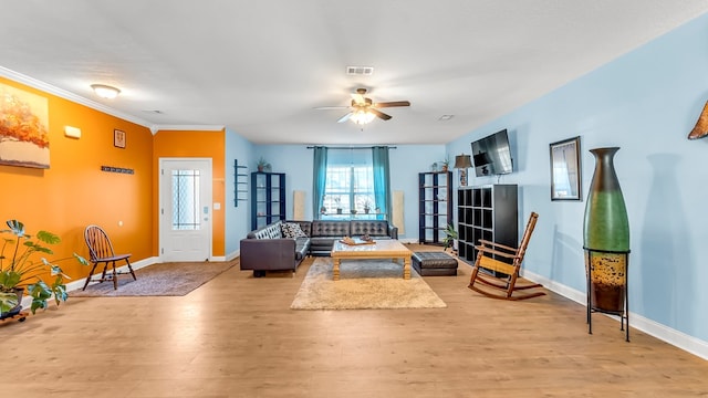 living room with ceiling fan, ornamental molding, and light hardwood / wood-style flooring