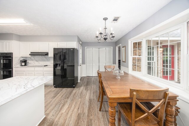 6909 Trapper Way, Midland, GA 31820 - dining area featuring a chandelier and light wood-style floors
