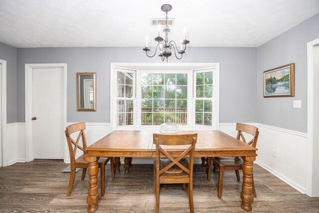 6909 Trapper Way, Midland, GA 31820 - dining area featuring a chandelier, wood finished floors, and a textured ceiling