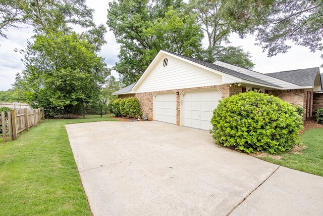 6909 Trapper Way, Midland, GA 31820 - view of side of property featuring concrete driveway, brick siding, an attached garage, and roof with shingles