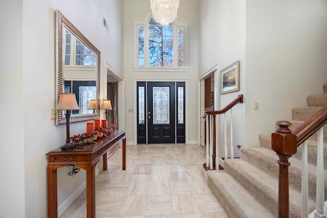 foyer entrance with a chandelier and a towering ceiling