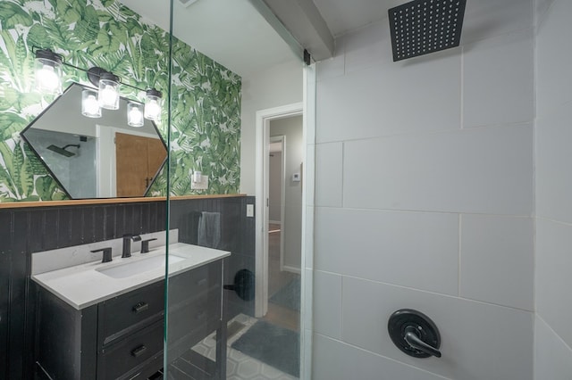 bathroom with vanity, tile patterned floors, wallpapered walls, beamed ceiling, and tiled shower