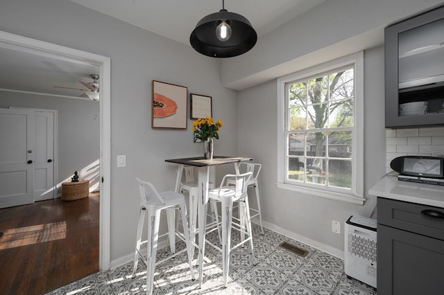 dining room featuring baseboards, ceiling fan, and visible vents