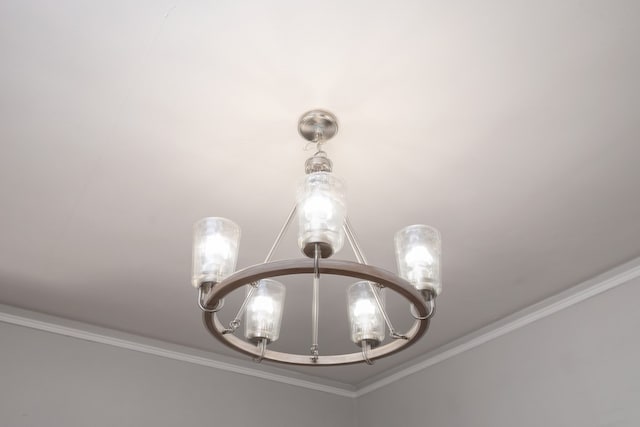 interior details with ornamental molding and a notable chandelier