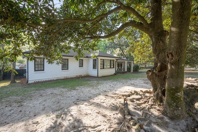 view of front of house featuring brick siding and fence
