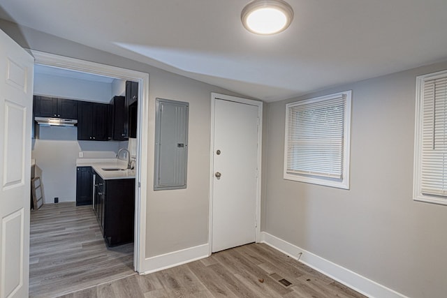 interior space featuring electric panel, sink, and light wood-type flooring