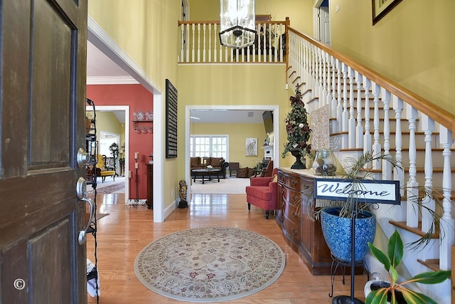 entryway featuring ornamental molding, light hardwood / wood-style flooring, and a chandelier