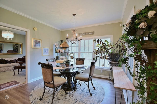 dining area with crown molding, dark hardwood / wood-style flooring, and an inviting chandelier