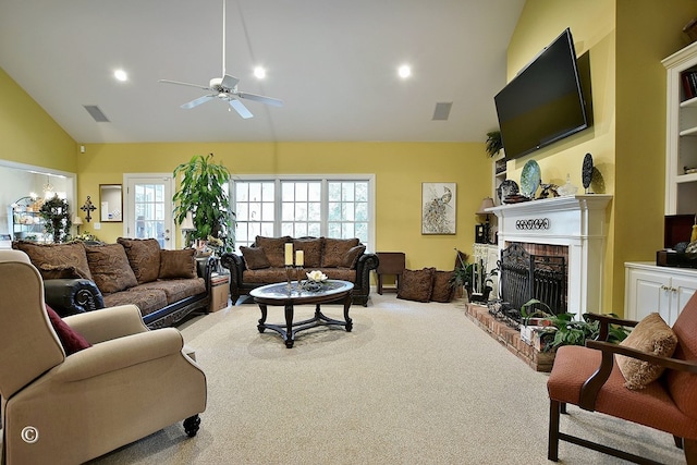 carpeted living room featuring a fireplace, high vaulted ceiling, and ceiling fan